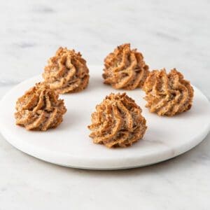 A white plate topped with four cookies on top of a table.